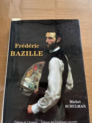 the book is sitting on a table with a painting on it
