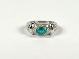 a close up of a ring with a green stone on it