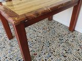 a wooden table with a wooden top on a tiled floor