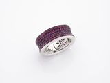 un gros plan d'une bague ornée de pierres roses sur fond blanc