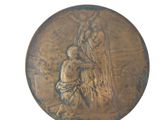 a bronze medal with an image of a man and a dog