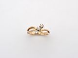 a close up of a gold ring with two diamonds on it