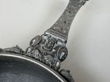 a silver spoon sitting on top of a metal pan