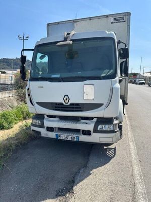 un camion blanc garé sur le bord de la route