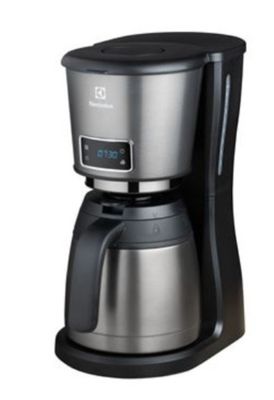 La cafetière est posée sur une surface blanche recouverte d'un couvercle noir.