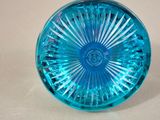 a blue glass object on a table with a white background