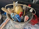 a bucket filled with assorted items on a table in the back of a car
