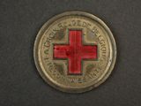 an old red cross coin on a black surface