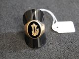 un gros plan d'une bague noire et dorée à laquelle est attachée une étiquette