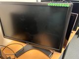a computer monitor sitting on top of a wooden desk