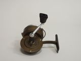 a close up of a fishing reel on a white surface
