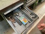un tiroir rempli d'outils dans un magasin, avec une personne qui tend la main pour l'ouvrir