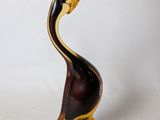 a glass sculpture of a bird that is sitting on a glass base