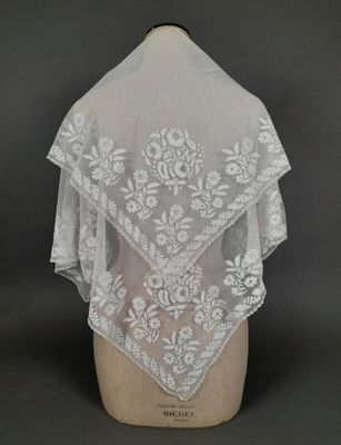 un gros plan d'un châle en dentelle blanche sur un mannequin