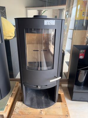 a black stove sitting on a pallet in the middle of a room