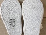 the soles of a pair of white slippers on a couch