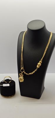 Ensemble composé d'un collier, d'une bague et d'un bracelet plaqués or, présenté sur un mannequin