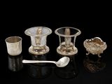 quatre tasses et cuillères en argent posées sur une surface noire