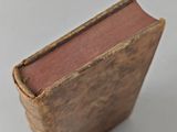 an old book sitting on top of a table next to a white table