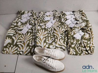 quatre paires de pantalons et une paire de chaussures par terre
