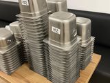 a stack of silver containers sitting on a wooden table