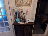 une petite table sur laquelle se trouve un vase, dans un coin de la pièce