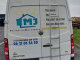 a van with a ladder on the back parked in a parking lot