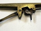 un petit objet en laiton sur lequel est représentée une paire de ciseaux