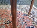 a wooden table with a red and blue rug on the floor