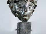 sculpture of a woman ' s head on a metal stand on a white background