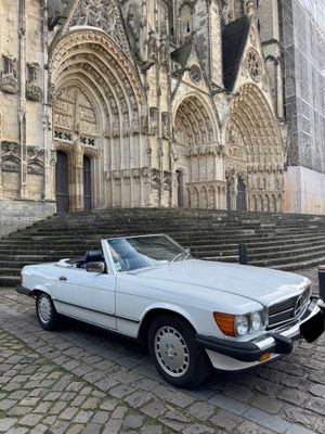 a white convertible car parked in front of a church