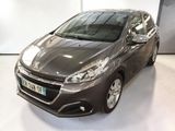 La voiture grise est garée dans une pièce blanche au sol blanc.