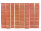 un lot de cinq livres posés sur une surface blanche