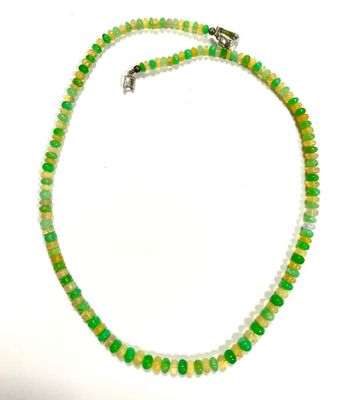 green and white beaded necklace on a white background
