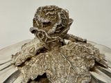 a silver plate with a rose on top of it