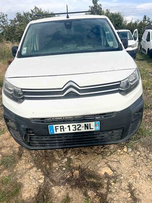 the white van is parked on the side of the dirt road