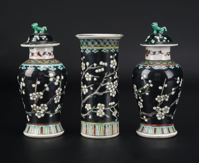 three black vases with flowers and birds on them on a black surface