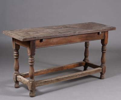 une vieille table en bois avec des pieds tournés et un plateau en bois