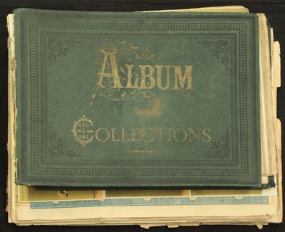 un vieil album à la couverture verte posé au sommet d'une pile de livres