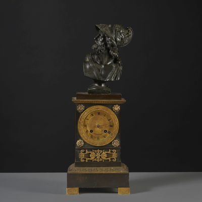 a statue of a man holding a clock on top of a table