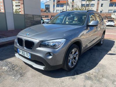 the bmw x1 is parked on the side of the road in a parking lot