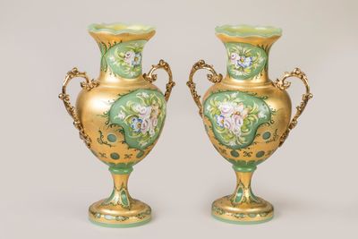 deux vases en or ornés de motifs verts et blancs