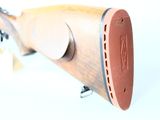 a wooden rifle that is on display on a white surface