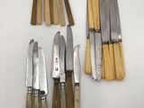 several knives and knives are lined up on a white surface