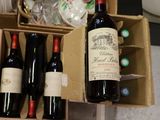 plusieurs bouteilles de vin rangées dans une caisse posée sur le comptoir