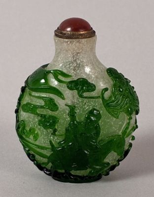 a green and white glass bottle with a red lid