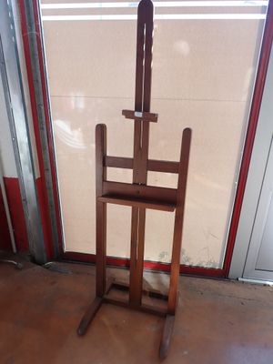 a wooden easel sitting in front of a glass door