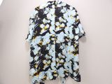 a black and yellow floral shirt hanging on a white wall