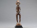 une statue en bois d'un homme avec un chapeau sur la tête