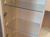 a cabinet with glass shelves in the corner of the room